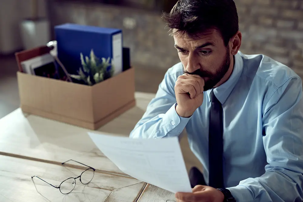 empresario-preocupado-passando-pela-papelada-depois-de-perder-o-emprego-no-escritorio 1