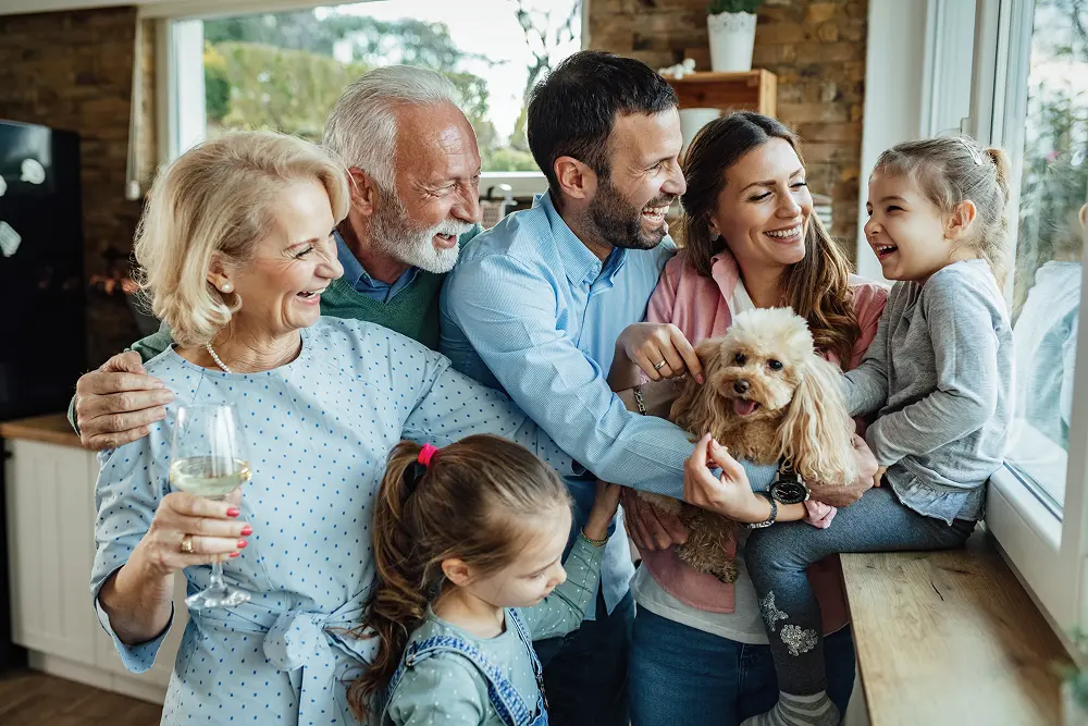 familia-alegre-de-varias-geracoes-com-um-cachorro-se-divertindo-enquanto-passa-o-tempo-juntos-em-casa 1