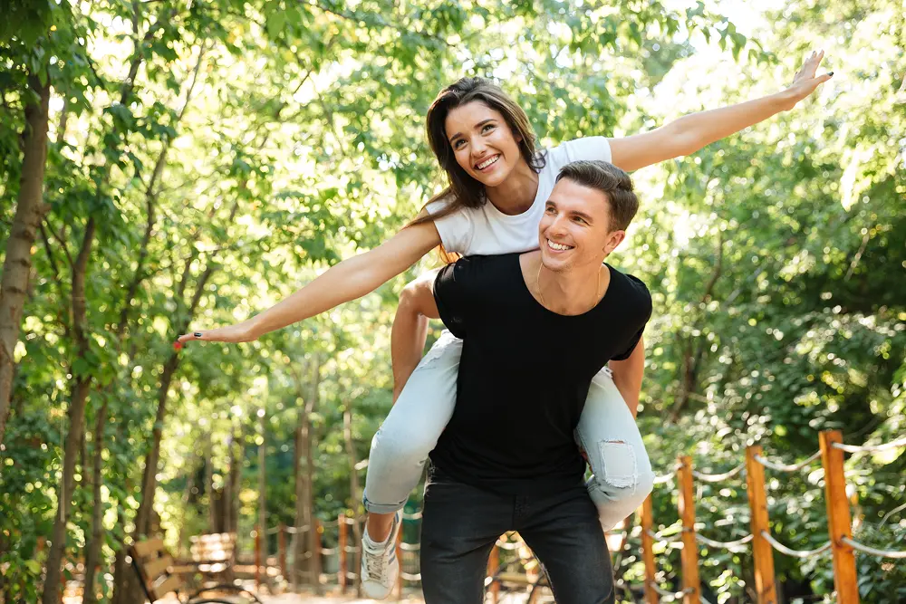 jovem-casal-sorridente-desfrutando-de-cavalinho-e-rindo