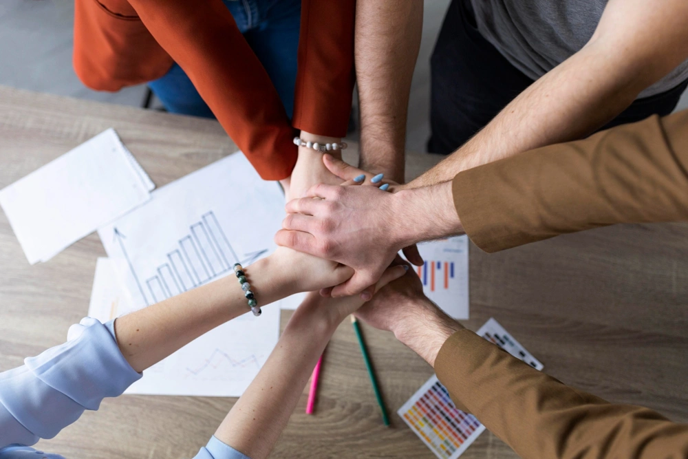 group-coworkers-putting-their-hands-together_1000x667