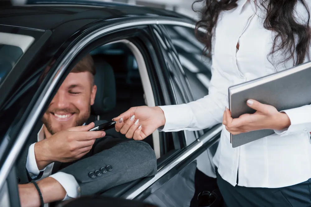 resized_can-t-handle-emotions-happy-owner-new-car-sitting-inside-takes-keys-from-female-manager